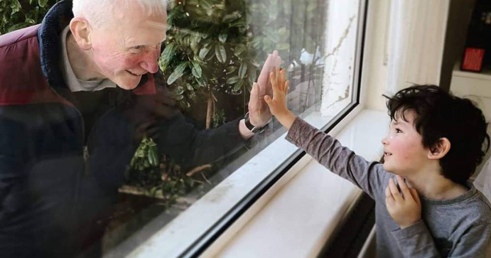 Coronavirus: Poignant image shows grandad touching grandson's hand through window - mirror.co.uk - Ireland