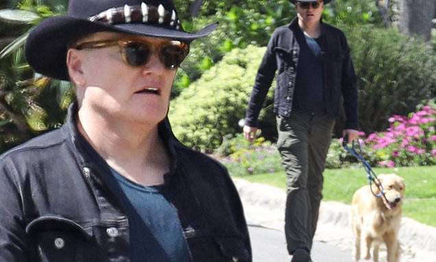Conan O'Brien walks his dogs with family as he prepares to broadcast show from home via iPhone - dailymail.co.uk