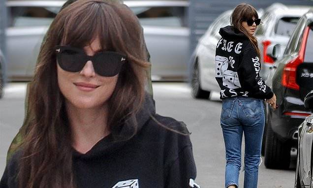Chris Martin - Dakota Johnson - Dakota Johnson is causally stylish in hoodie and ripped jeans as she goes for a stroll in LA - dailymail.co.uk - Los Angeles