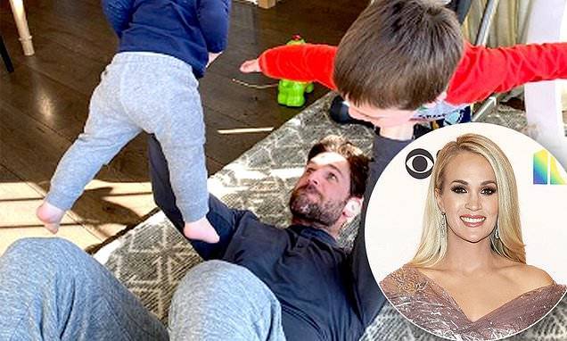 Mike Fisher - Carrie Underwood shows off husband Mike Fisher's strength as he bench presses sons during quarantine - dailymail.co.uk