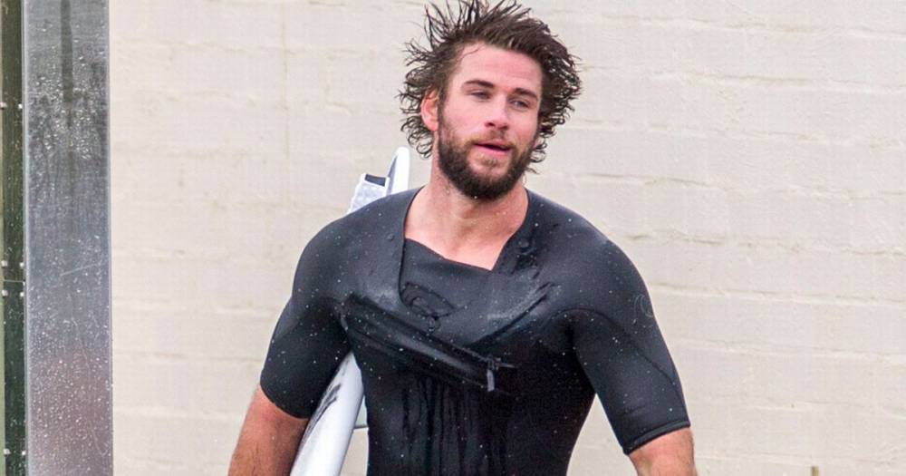 Liam Hemsworth - Liam Hemsworth squeezes into very tight wetsuit for surfing session in native Australia - mirror.co.uk - Australia - county Island