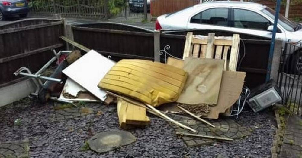 Fly-tippers have dumped a huge pile of rubbish in someone's front garden - including a weight bench, a mattress and even an old microwave - manchestereveningnews.co.uk