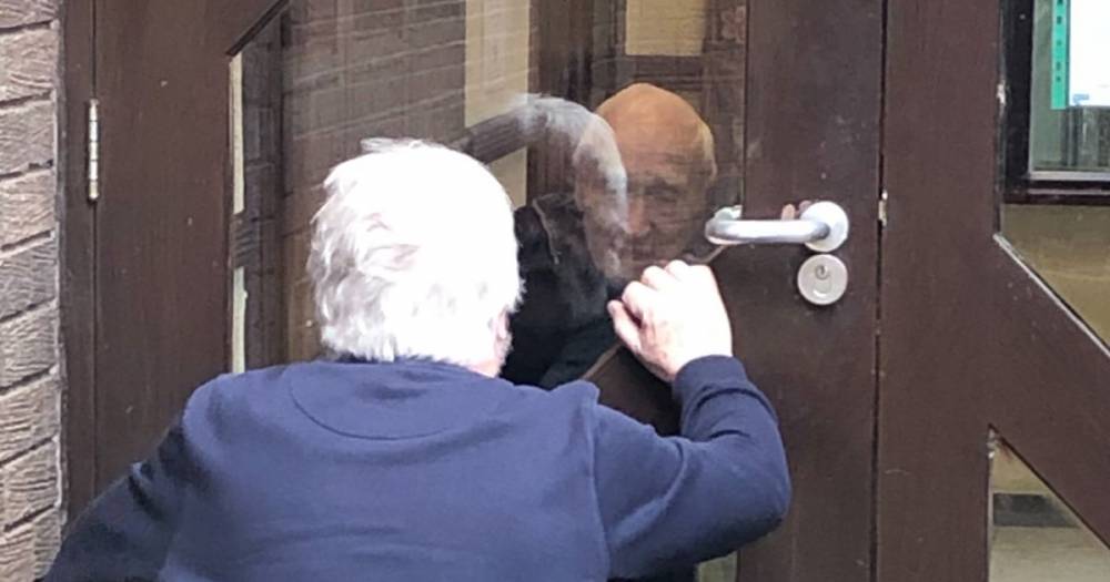 Coronavirus lockdown: Family visits 98-year-old war hero through window of his care home - mirror.co.uk - Britain - city Manchester
