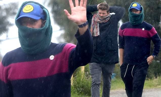 Chris Martin - Chris Martin waves to onlookers as he covers up with a scarf on rainy walk with a friend in Malibu - dailymail.co.uk - state California - city Malibu