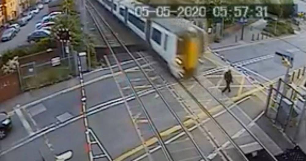 London - Man walks into path of oncoming train after ignoring signs in heart-stopping clip - dailystar.co.uk - Britain - county Cross