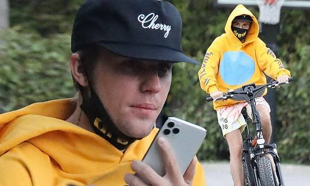 Justin Bieber - Justin Bieber chats on phone during a barefoot bike ride in Los Angeles...upon return from Canada - dailymail.co.uk - Los Angeles - Canada - city Los Angeles