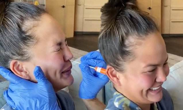 Chrissy Teigen - 'It tickles!' Chrissy Teigen squeals and giggles as she gets her nose swabbed during COVID-19 test - dailymail.co.uk