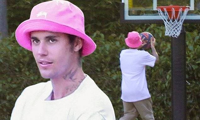 Justin Bieber - Justin Bieber dons Yummy shirt with pink bucket hat while shooting hoops in front of his house - dailymail.co.uk - Los Angeles - Canada