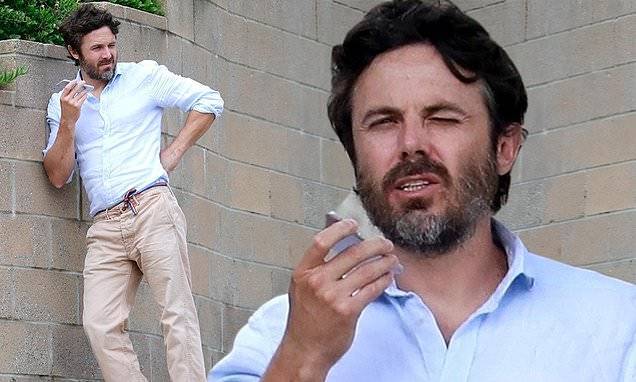 Joaquin Phoenix - Casey Affleck pairs his shaggy beard with a dapper linen shirt and khakis while taking a call in LA - dailymail.co.uk - city New York - Los Angeles - city Los Angeles