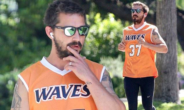Mia Goth - Shia LaBeouf dons a blinding neon orange basketball jersey during a solo run around his neighborhood - dailymail.co.uk