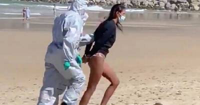 Police in hazmat suits drag surfer from beach after she tests positive for Covid-19 - dailystar.co.uk - Spain