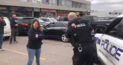 Coronavirus Ontario - COVID-19: Peel police officer accuses Global News journalist of agitating protesters, hugs attendees - globalnews.ca - city Ontario