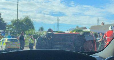 Emergency services descend on road as car left on side following crash - manchestereveningnews.co.uk - city Manchester